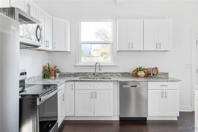 kitchen featuring appliances with stainless steel finishes, white cabinetry, a healthy amount of sunlight, and sink