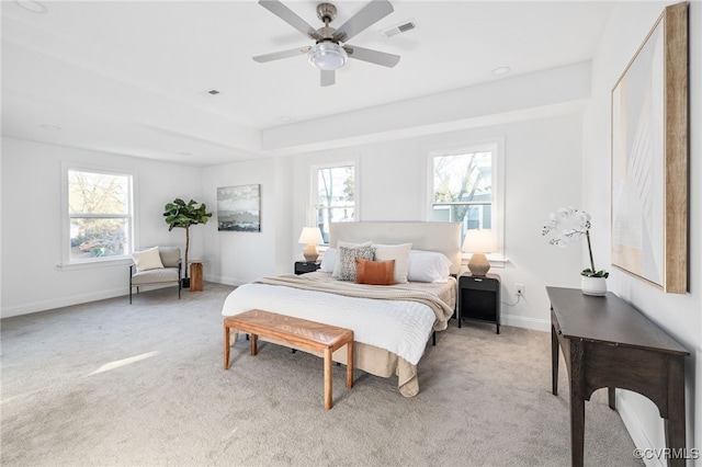 carpeted bedroom with multiple windows and ceiling fan