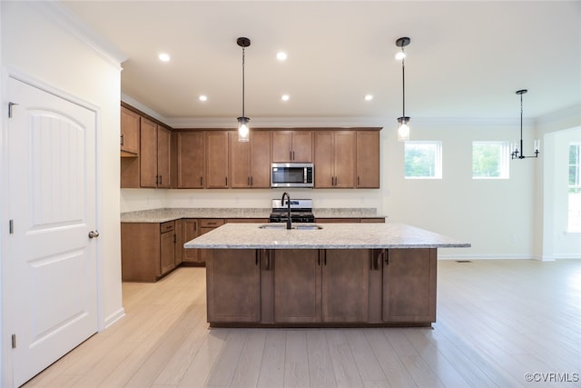 kitchen featuring light stone countertops, light hardwood / wood-style floors, sink, and appliances with stainless steel finishes