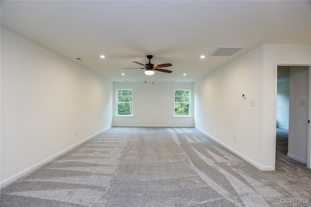 empty room featuring ceiling fan and light carpet