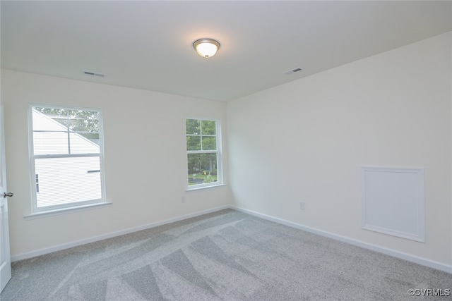 spare room featuring light colored carpet