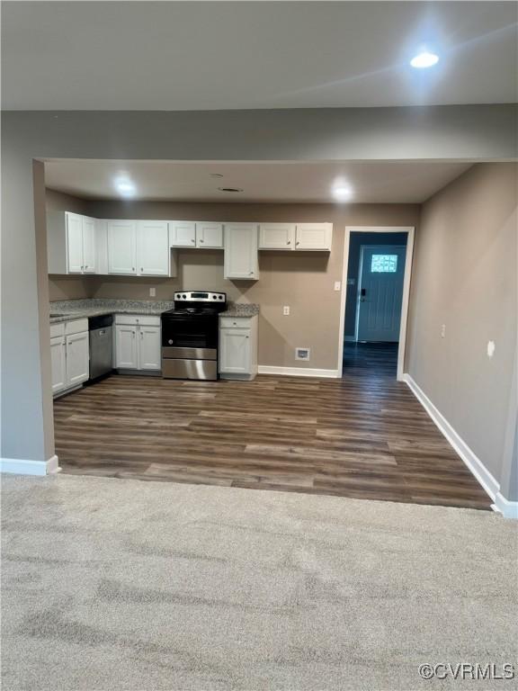 kitchen with appliances with stainless steel finishes, dark hardwood / wood-style flooring, and white cabinetry