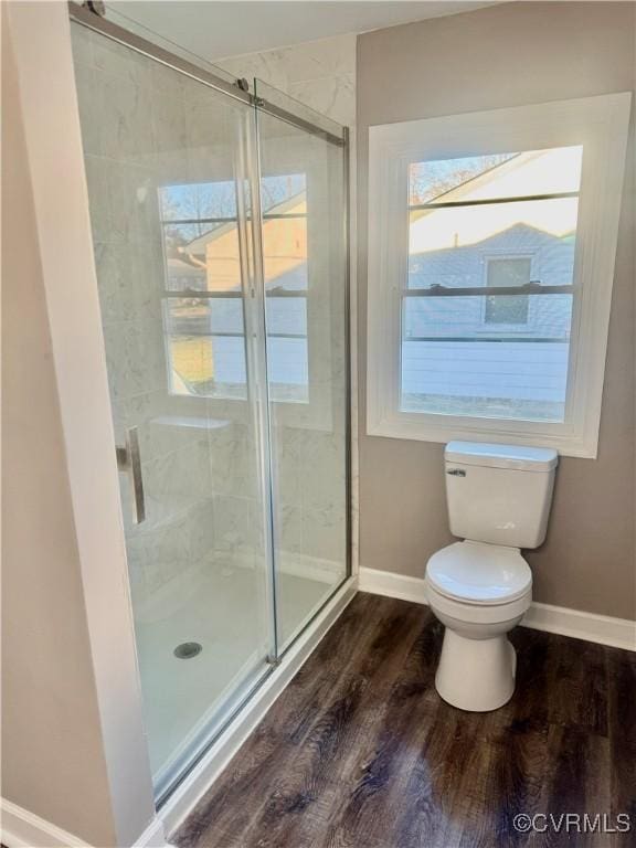 bathroom featuring a shower with shower door, toilet, and wood-type flooring