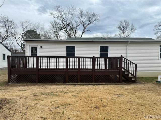 back of house featuring a lawn and a wooden deck