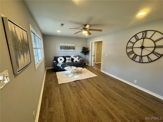 unfurnished living room featuring dark wood-type flooring and ceiling fan