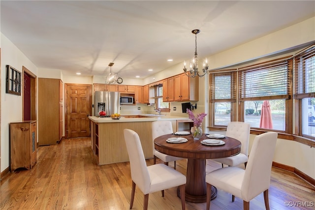 dining space featuring light hardwood / wood-style floors, sink, and a chandelier