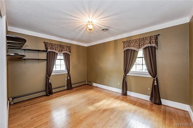 unfurnished bedroom with a textured ceiling, light hardwood / wood-style floors, and multiple windows