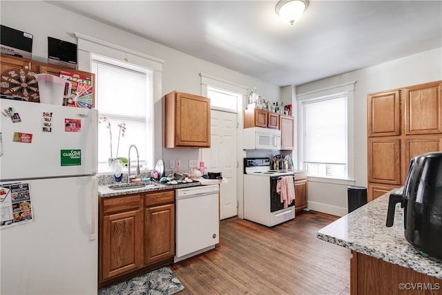 kitchen featuring plenty of natural light, dark hardwood / wood-style floors, white appliances, and sink