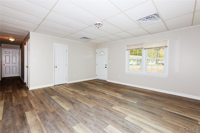 spare room featuring a paneled ceiling and wood-type flooring