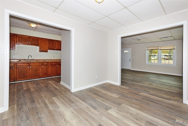 interior space featuring hardwood / wood-style floors, sink, and a drop ceiling