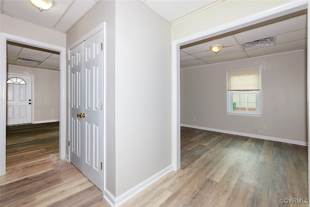 hallway with a drop ceiling and wood-type flooring