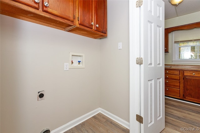 washroom featuring electric dryer hookup, cabinets, dark hardwood / wood-style floors, and washer hookup