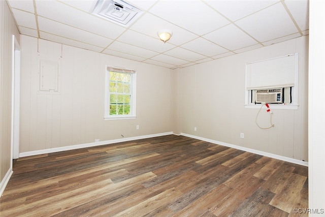 empty room with a paneled ceiling, cooling unit, and dark hardwood / wood-style floors