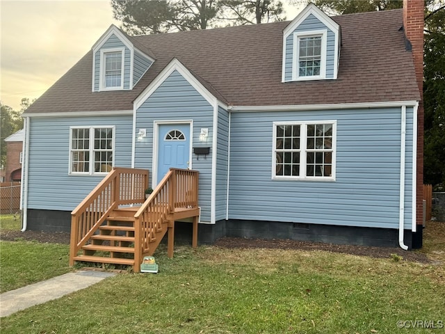 cape cod home featuring a lawn