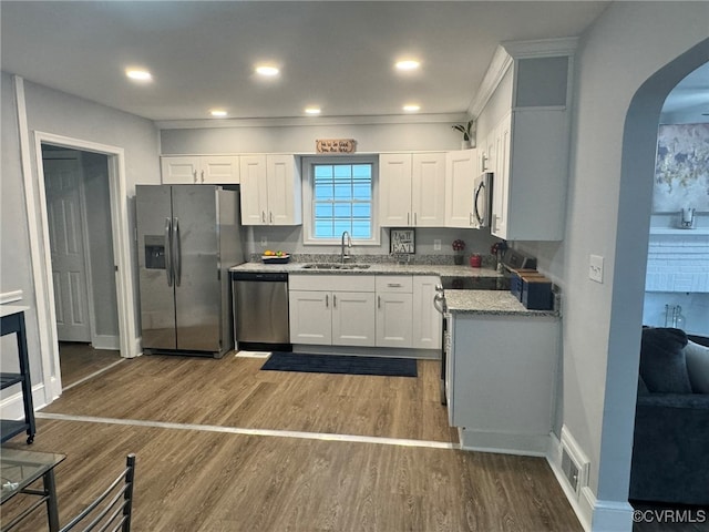 kitchen featuring stainless steel appliances, stone countertops, sink, dark hardwood / wood-style floors, and white cabinets