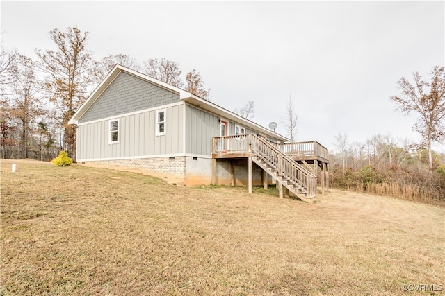 rear view of house featuring a yard and a deck