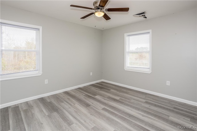 empty room featuring light hardwood / wood-style floors, a wealth of natural light, and ceiling fan