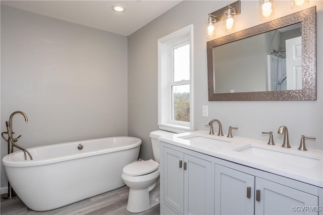 full bathroom with hardwood / wood-style floors, vanity, independent shower and bath, and toilet