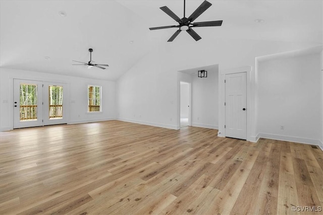unfurnished living room with light wood-type flooring, baseboards, ceiling fan, and high vaulted ceiling