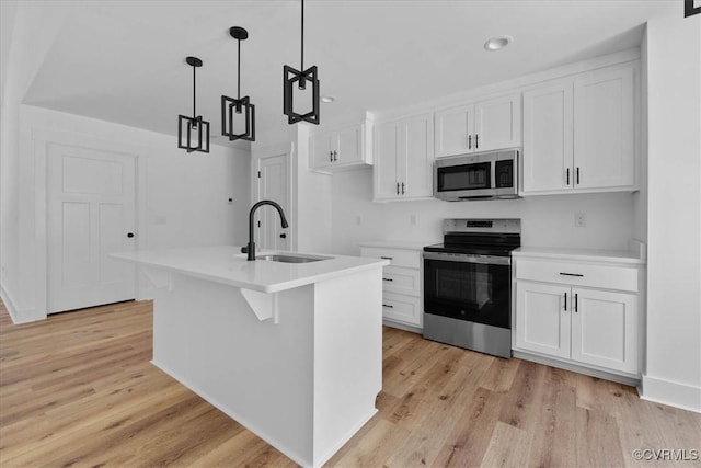 kitchen featuring white cabinetry, light wood-style floors, appliances with stainless steel finishes, and a sink