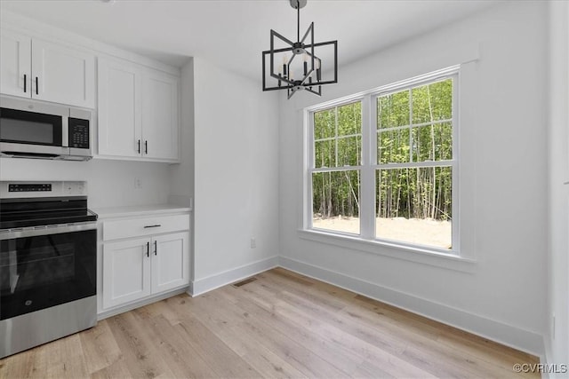 kitchen featuring baseboards, stainless steel appliances, white cabinetry, and visible vents
