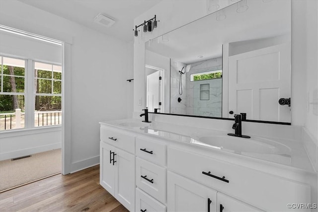 bathroom featuring a sink, baseboards, a shower stall, and visible vents