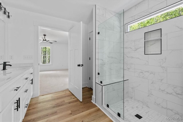 full bathroom with walk in shower, vanity, ceiling fan, and wood finished floors