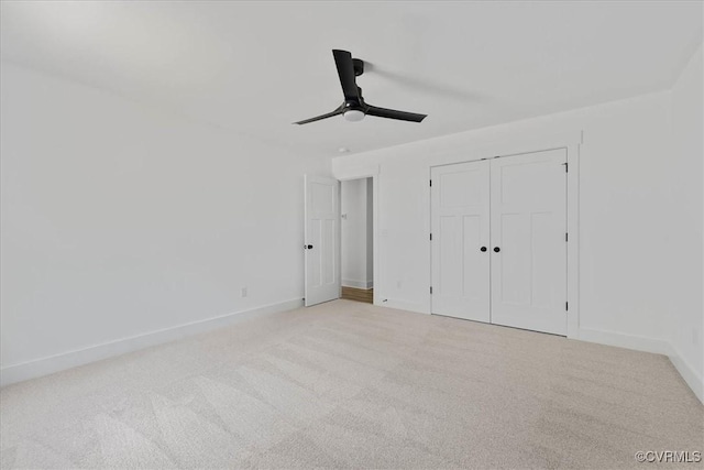 unfurnished bedroom with carpet flooring, baseboards, a ceiling fan, and a closet