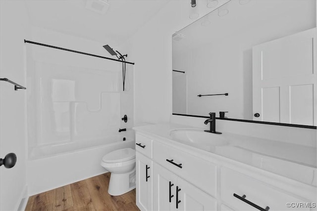 bathroom with vanity, toilet, shower / tub combination, and wood finished floors