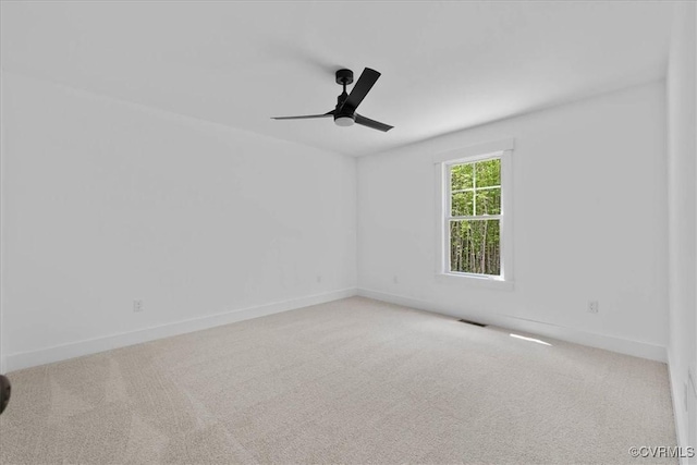 empty room featuring baseboards, visible vents, ceiling fan, and carpet floors