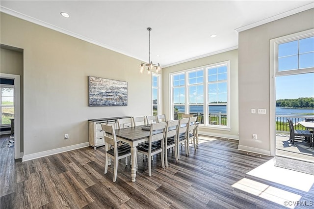 dining area featuring a water view, ornamental molding, dark wood-type flooring, and a chandelier