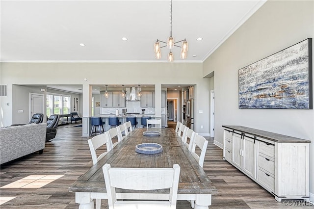 dining area featuring dark hardwood / wood-style floors, crown molding, and a notable chandelier