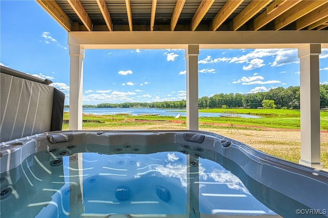 view of swimming pool featuring a water view and a hot tub