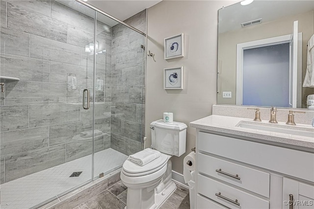 bathroom with wood-type flooring, vanity, toilet, and a shower with shower door