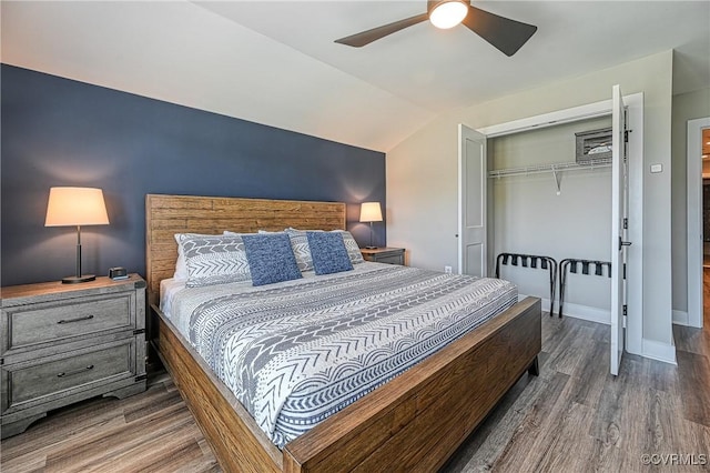 bedroom featuring ceiling fan, dark hardwood / wood-style floors, lofted ceiling, and a closet