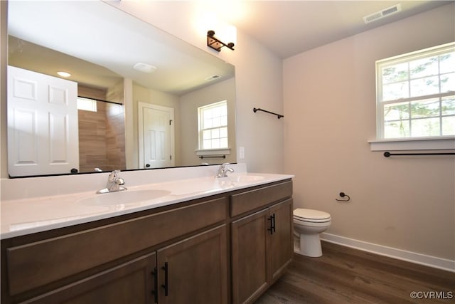 bathroom with double vanity, a sink, visible vents, and baseboards