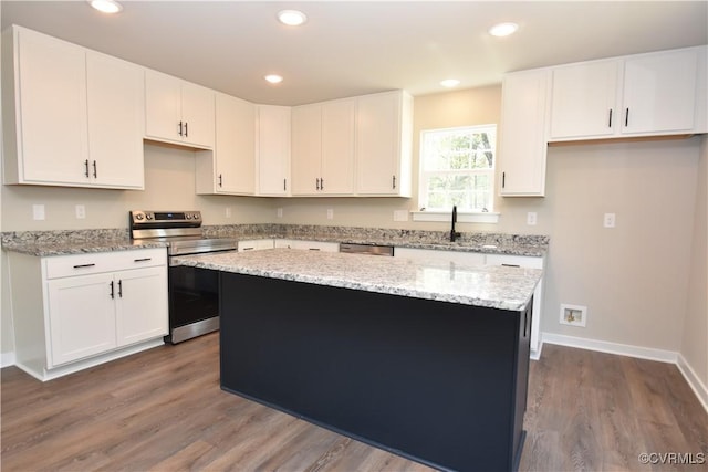 kitchen with appliances with stainless steel finishes, recessed lighting, white cabinetry, and a center island