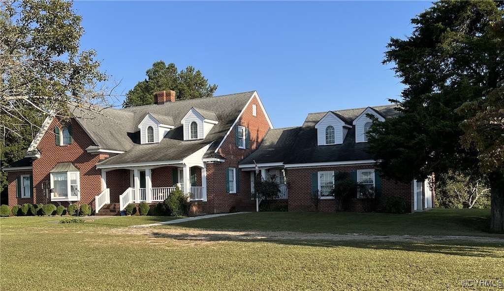 cape cod-style house with covered porch and a front yard