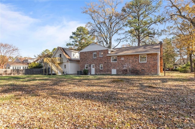 rear view of property with a lawn and cooling unit