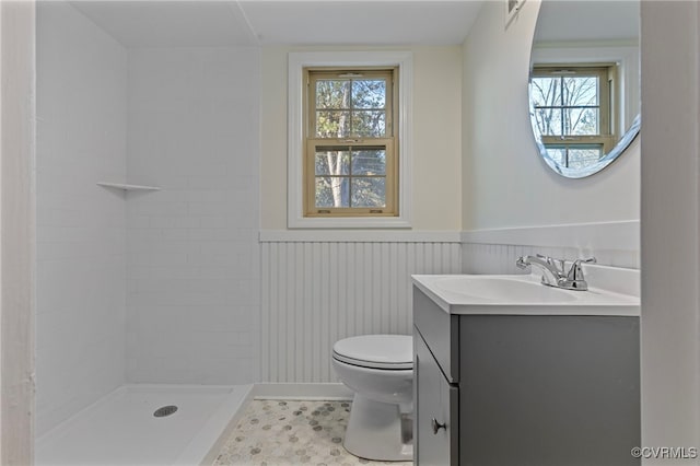 bathroom with tile patterned floors, toilet, vanity, and tiled shower