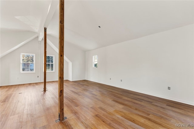 additional living space with hardwood / wood-style flooring and vaulted ceiling