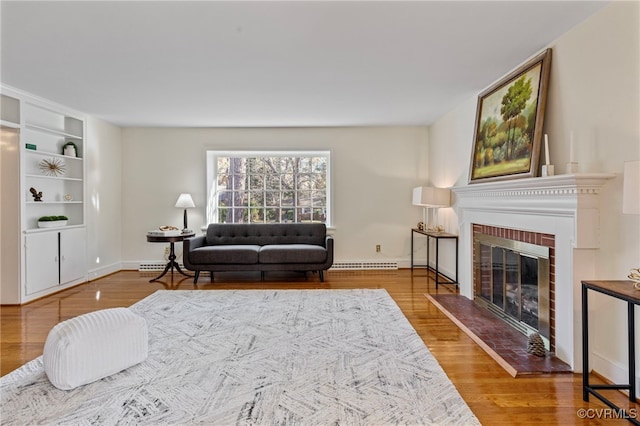 living room featuring hardwood / wood-style flooring, a baseboard radiator, and a brick fireplace