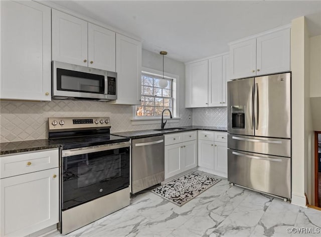 kitchen with white cabinets, sink, decorative backsplash, decorative light fixtures, and stainless steel appliances