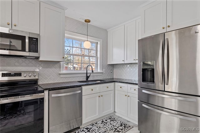 kitchen with dark stone countertops, sink, white cabinets, and stainless steel appliances