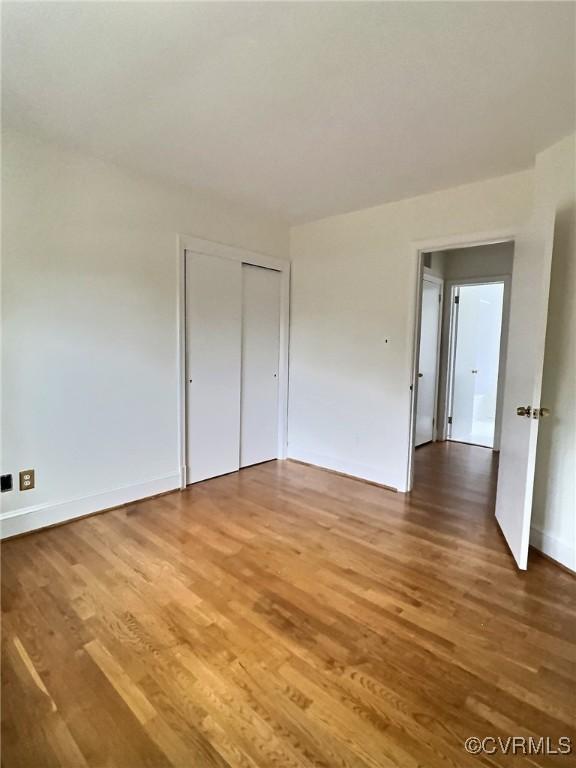 unfurnished bedroom featuring hardwood / wood-style floors and a closet