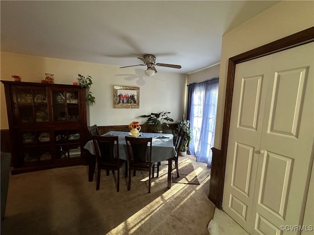 carpeted dining area with ceiling fan