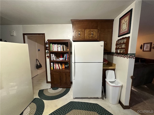 kitchen with light tile patterned flooring and white refrigerator