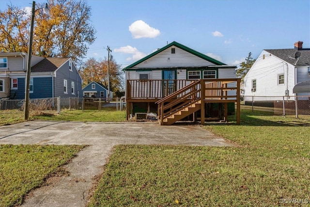 rear view of property featuring a yard, a deck, and a patio area