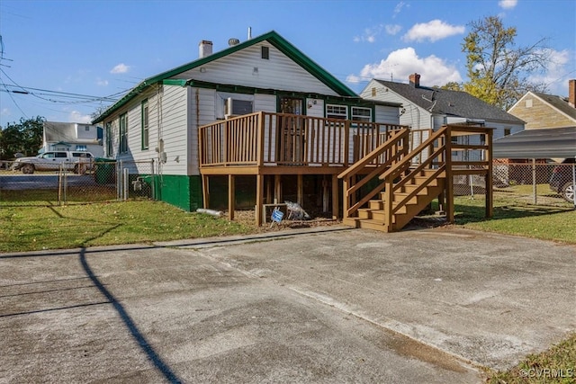 back of property with a yard and a wooden deck