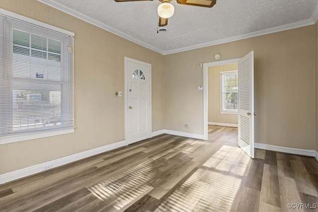 empty room featuring a textured ceiling, hardwood / wood-style flooring, ceiling fan, and ornamental molding